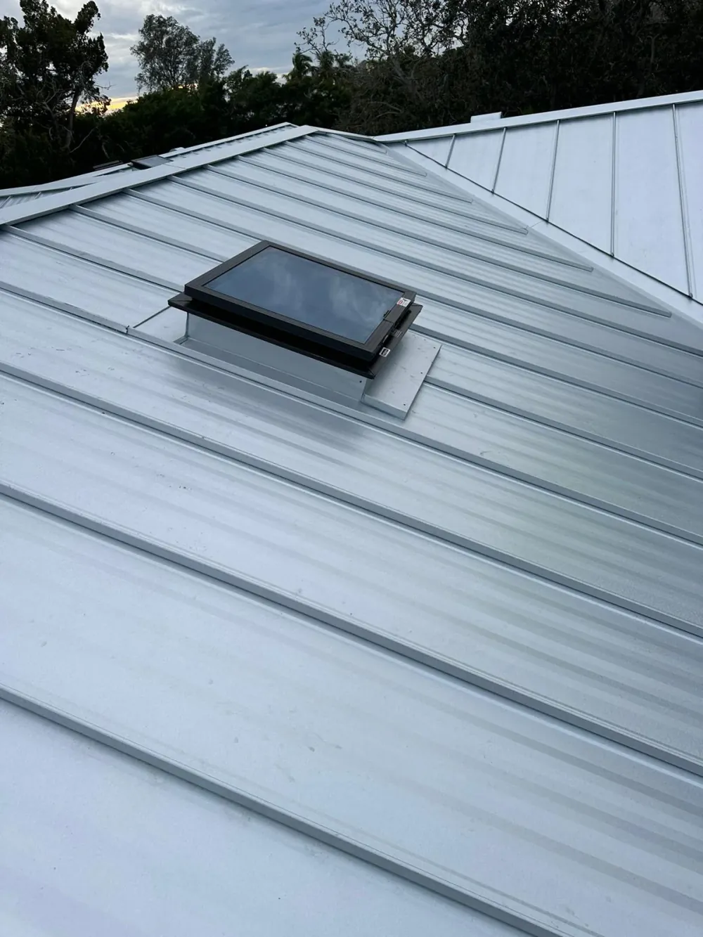 Metal roofing crew installing standing seam panels in Sarasota, FL
