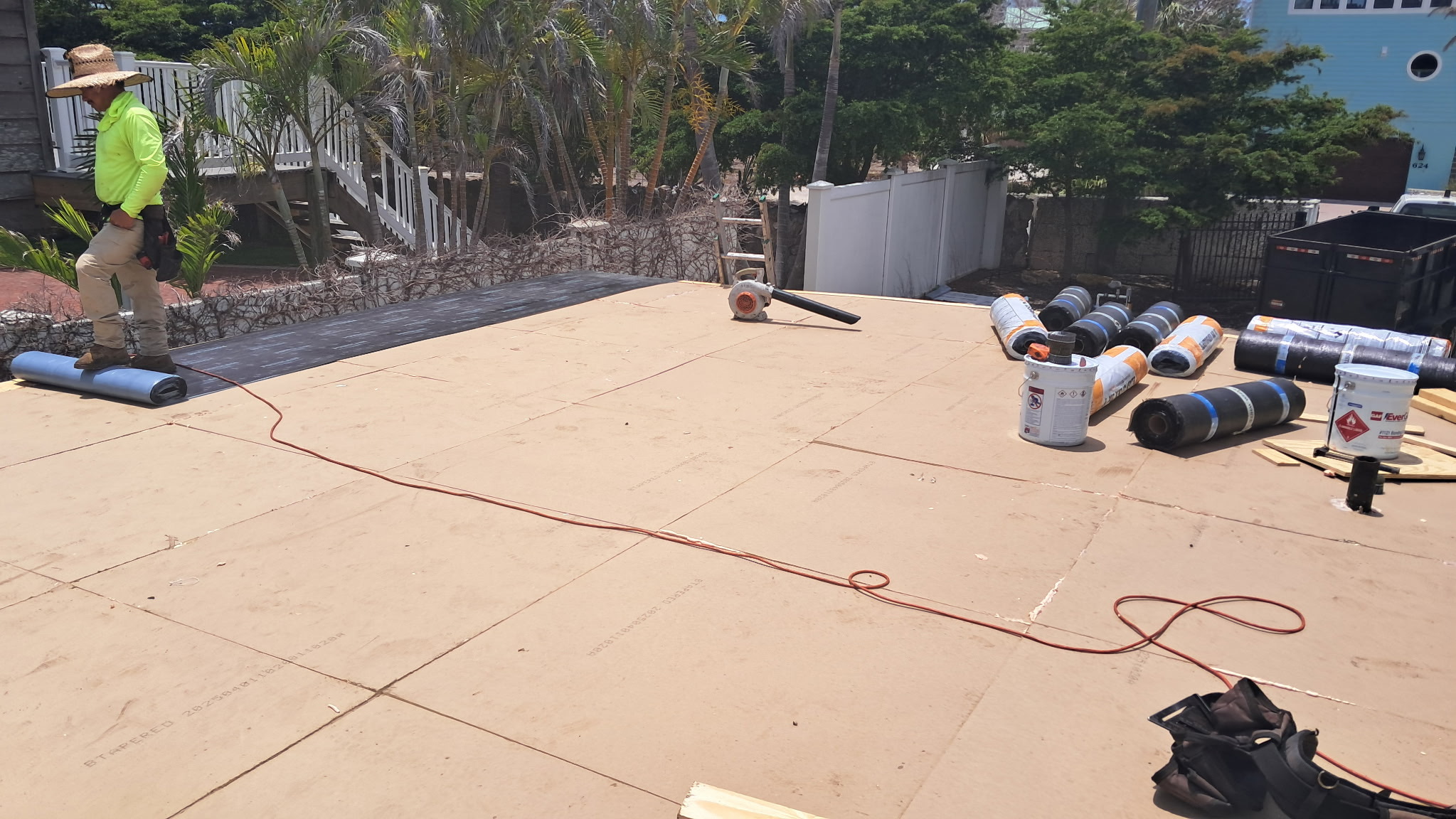 Crew installing modified bitumen membrane over OSB deck in Sarasota