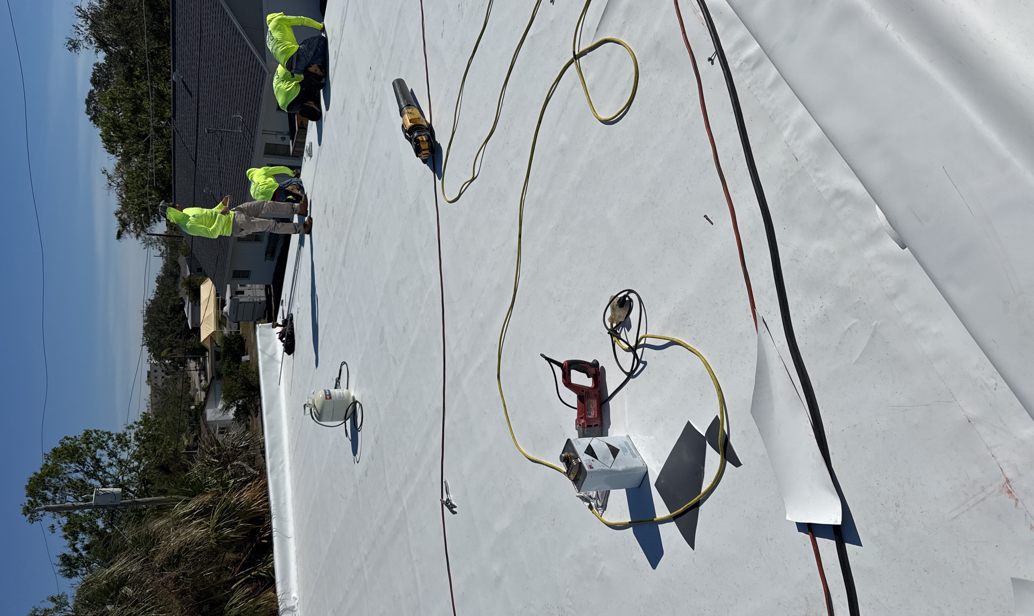 SRQ crew installing white TPO membrane on a commercial flat roof in Sarasota