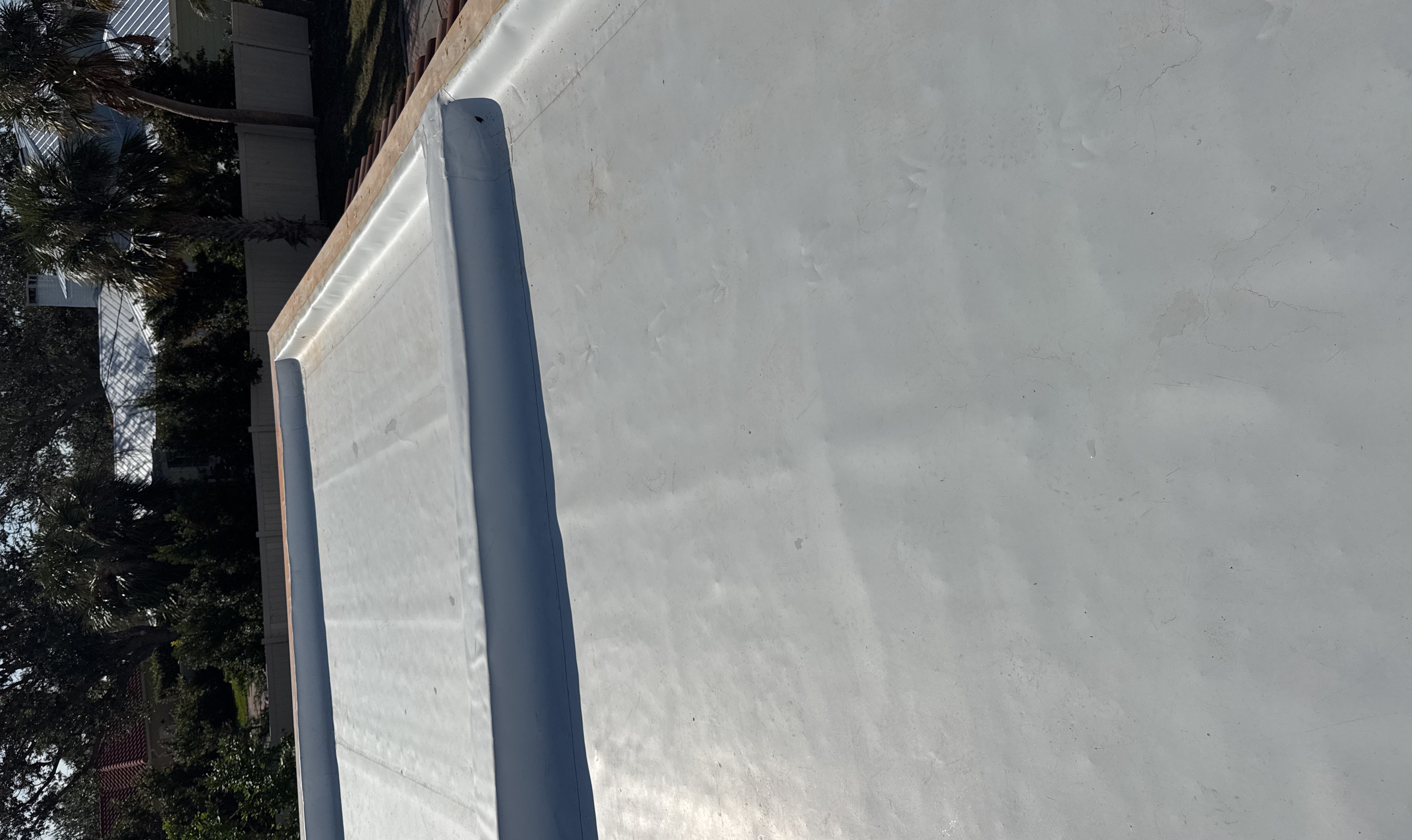 White TPO single-ply membrane with parapet wall on a residential addition in Sarasota